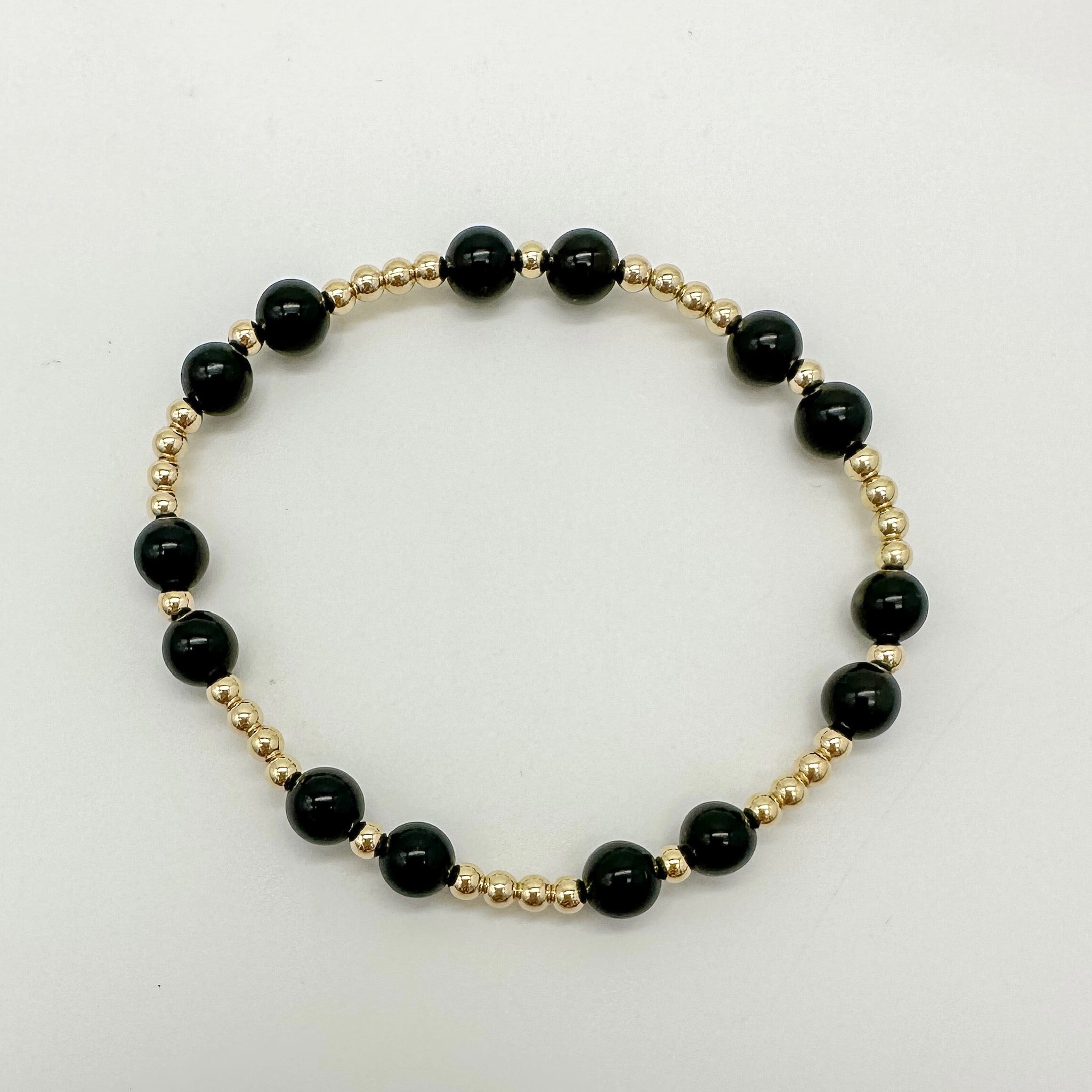 black beaded bracelet with gold-filled accents, handmade, small business, essbe, 14k gold-filled beads, black bracelet, elastic bracelet, evelyn beaded bracelet